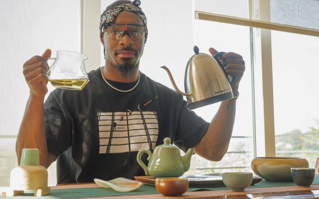 Taurean Nixon is holding a 탑 카지노사이트 kettle and Brewista glass server while going through his tea ritual.